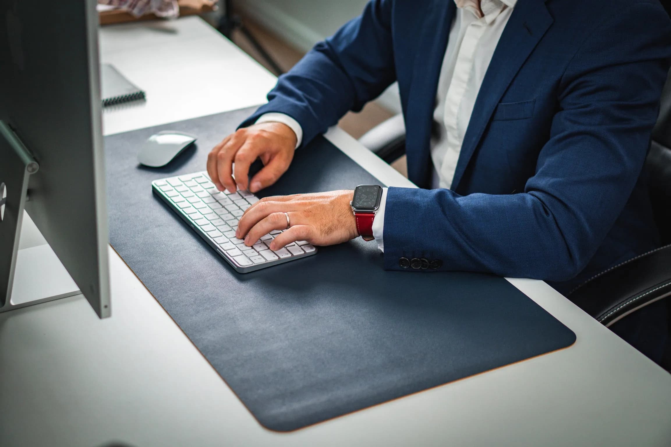 ETERNEL leather strap worn on the wrist, at a desk in front of a keyboard